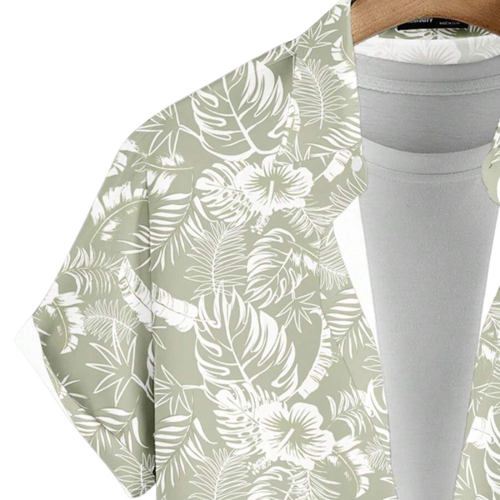 Detalhe da Camisa Vinser Alvorada, destacando a estampa tropical em tons de verde-claro e branco, com folhas e flores, além do acabamento da gola e do tecido leve.