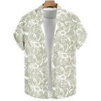 Vista frontal da Camisa Vinser Alvorada, com estampa tropical em folhas e flores brancas sobre fundo verde-sálvia, manga curta, tecido leve e acabamento premium.
