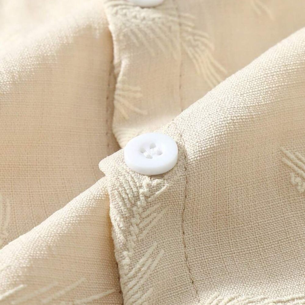 Detalhe do tecido da Camisa Vinser Areia, destacando a textura em relevo, o acabamento refinado e o tecido leve na cor bege claro, ideal para conforto e elegância.