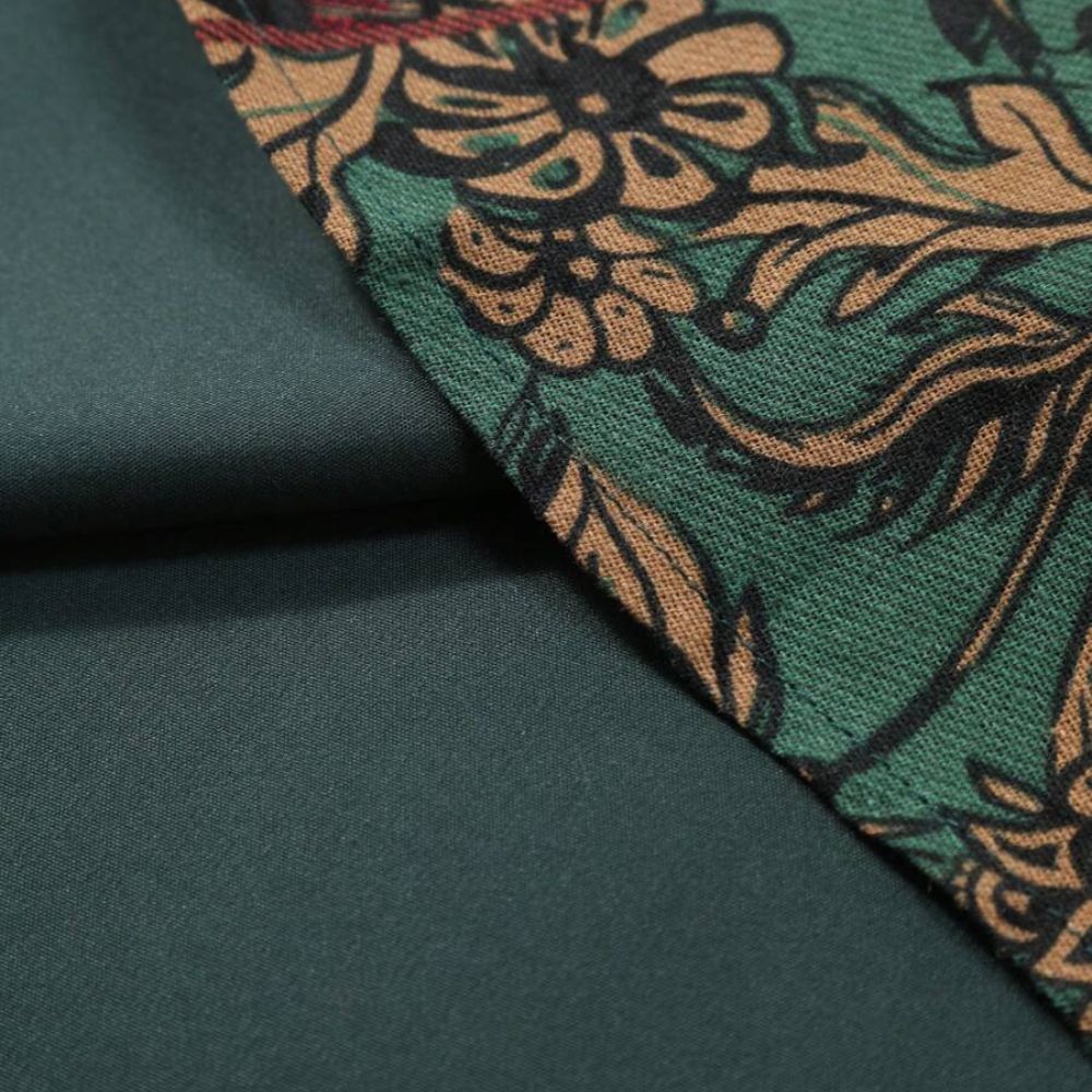 Detalhe do tecido da camisa masculina Vinser Armação, mostrando a combinação de tecido verde liso com painel estampado floral.