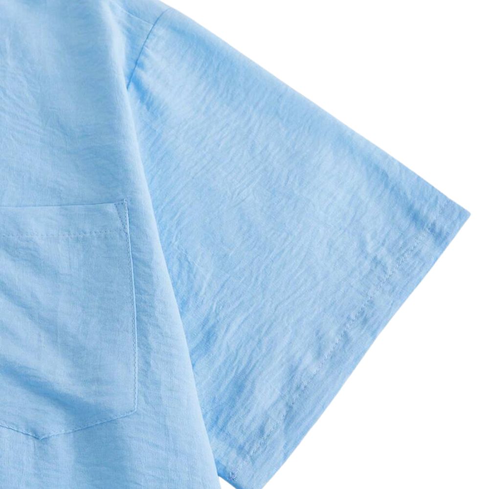Detalhe da manga da Camisa Vinser Azur na cor azul-claro, evidenciando o acabamento impecável, a costura reforçada e o tecido leve com caimento confortável.