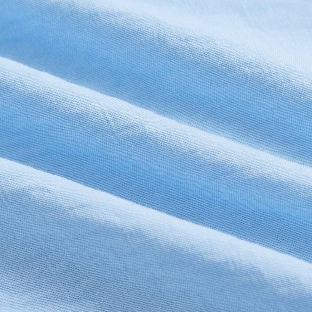 Detalhe do tecido da Camisa Vinser Azur em azul-claro, destacando a textura suave, o acabamento refinado e o tecido leve e respirável para máximo conforto.