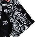 Detalhe da manga da Camisa Vinser Bandol, destacando o acabamento dobrado, as costuras reforçadas e a estampa patchwork bandana em preto, branco e rosa, evidenciando a leveza do tecido e a qualidade dos acabamentos.