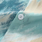 Detalhe da estampa da Camisa Vinser Brisa Marítima, destacando o tecido leve, o botão frontal e o acabamento em tons de azul, verde e bege inspirados no movimento do mar.