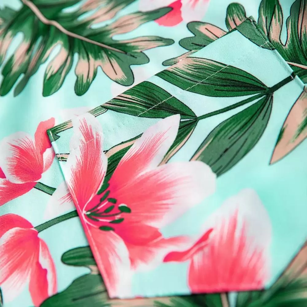 Detalhe da estampa da Camisa Vinser Brisa Rosa, destacando o tecido leve, o acabamento e o padrão floral tropical com flores rosas e folhas verdes sobre fundo verde-claro.