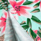 Detalhe do tecido da Camisa Vinser Brisa Rosa, evidenciando a estampa floral tropical em flores rosas e folhas verdes sobre fundo verde-claro, com acabamento leve e caimento suave.