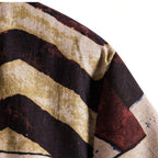 Detalhe da manga da camisa masculina Vinser Búzios com estampa geométrica abstrata em tons terrosos, vinho, bege e preto.
