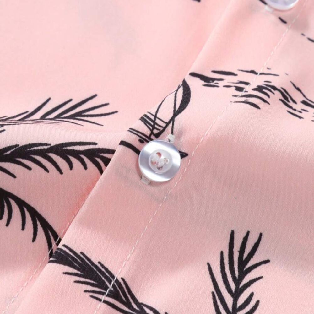 Detalhe do tecido da camisa masculina Vinser Campeche Rosa, com estampa tropical em preto sobre fundo rosa, destacando os botões, o acabamento da costura e a textura leve do material.