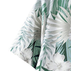 Detalhe do tecido da camisa masculina Vinser Comporta branca com estampa de folhagens e flores tropicais em tons de verde.