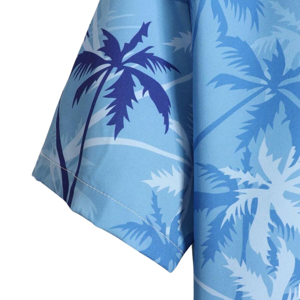 Close da manga da Camisa Vinser Costa Azul Claro, destacando a estampa tropical de coqueiros em tons de azul-claro, o tecido leve, o caimento da manga curta e o acabamento premium da peça.