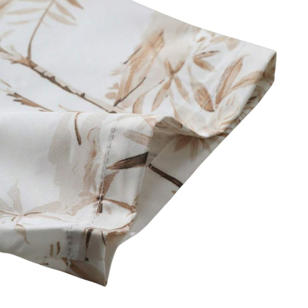 Detalhe da manga da Camisa Vinser Costa, destacando o acabamento refinado, a costura de qualidade e a estampa tropical em tons de branco e bege.