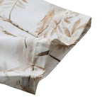 Detalhe da manga da Camisa Vinser Costa, destacando o acabamento refinado, a costura de qualidade e a estampa tropical em tons de branco e bege.