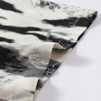 Detalhe da manga da Camisa Vinser Costa Noturna, destacando a barra com acabamento reforçado e a estampa abstrata em preto, branco e cinza sobre tecido leve.
