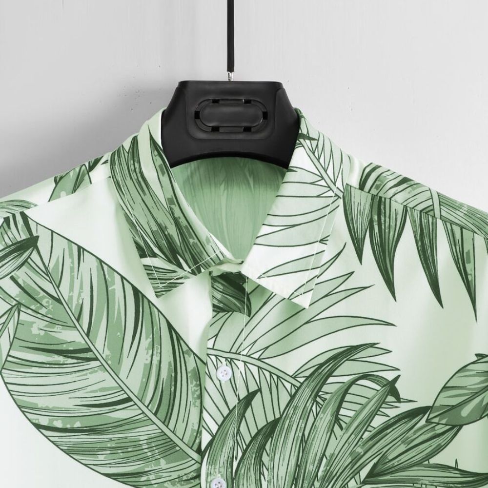 Detalhe da gola da Camisa Vinser Costa Verde, destacando o acabamento refinado, costura de qualidade e estampa tropical de folhas verdes.
