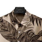 Detalhe da gola da Camisa Vinser Duna Atlântica, com estampa tropical de folhas em tons de marrom sobre fundo bege, destacando o acabamento da gola e a qualidade da costura.