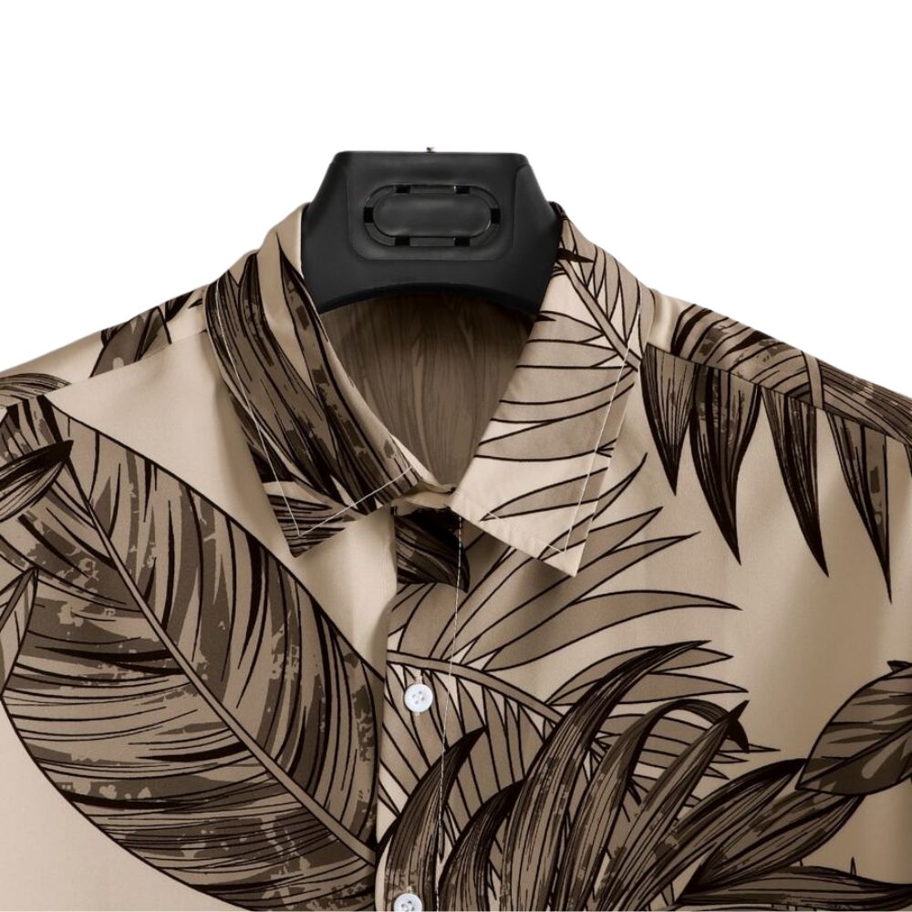 Detalhe da gola da Camisa Vinser Duna Atlântica, com estampa tropical de folhas em tons de marrom sobre fundo bege, destacando o acabamento da gola e a qualidade da costura.