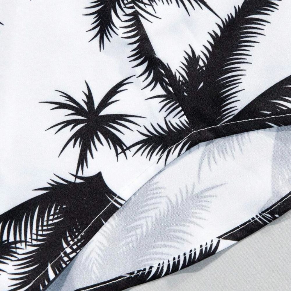 Detalhe do tecido da camisa masculina Vinser Espelho branca com estampa de coqueiros pretos, acabamento premium e costuras refinadas