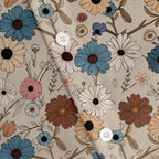 Detalhe do tecido da Camisa Vinser Flores do Paraíso, evidenciando a estampa floral em tons de bege, azul, branco, rosa e marrom, além dos botões e do acabamento de alta qualidade.