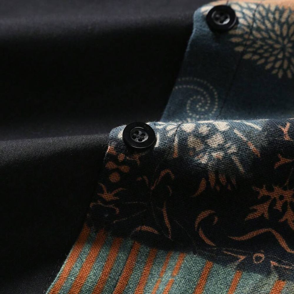 Detalhe da camisa masculina Vinser Guajiru com botões pretos e estampa patchwork em tons de azul, bege e terracota.