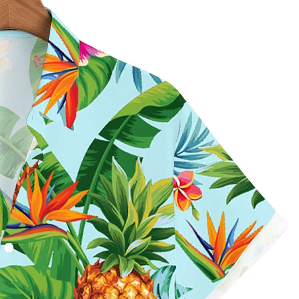 Detalhe da manga da Camisa Vinser Honolulu com estampa tropical em fundo azul-claro, destacando folhas, flores e abacaxis coloridos, além do acabamento refinado, das costuras reforçadas e do tecido leve e respirável.