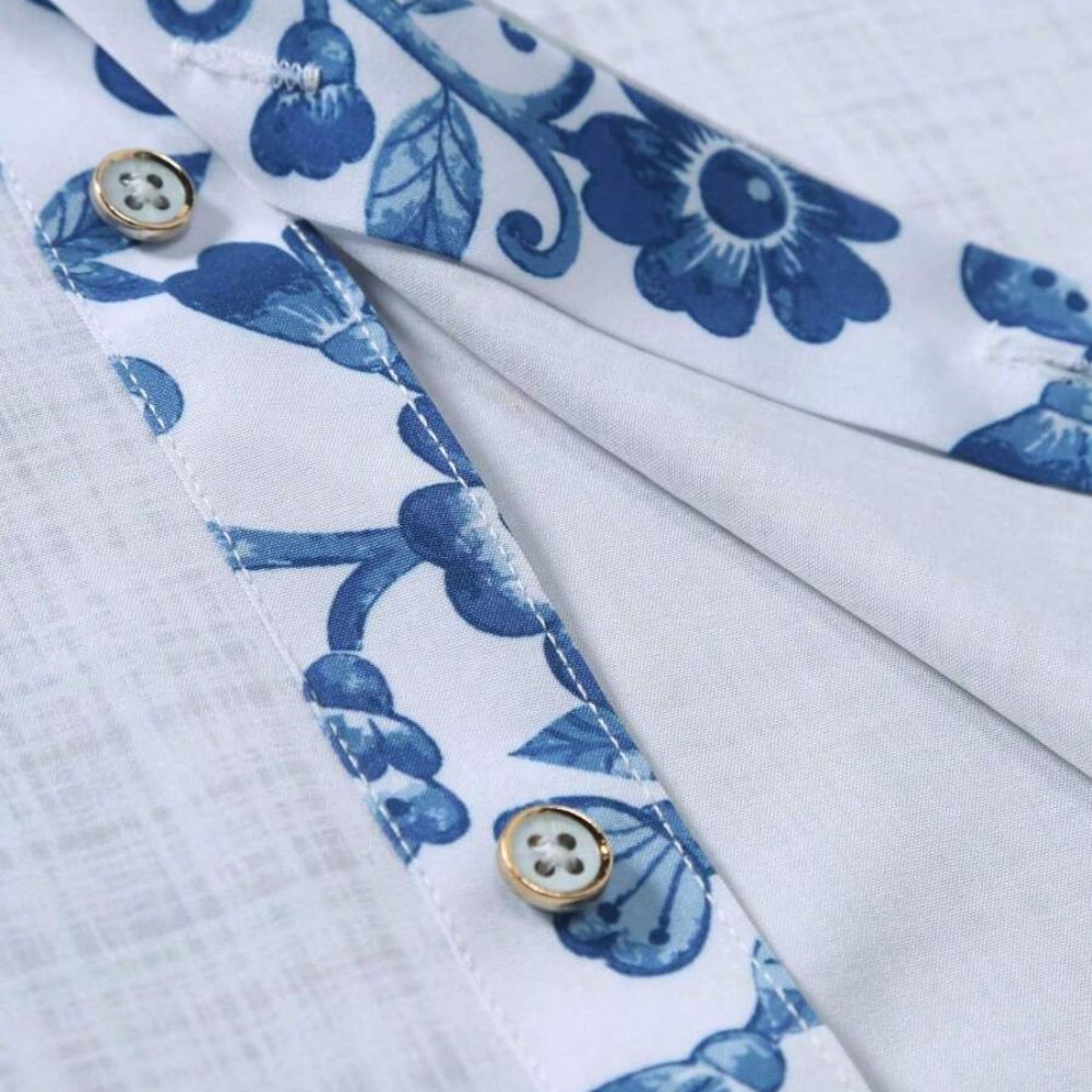Detalhe do tecido da camisa masculina Vinser Iracema branca com acabamento floral azul, botões premium e costuras refinadas
