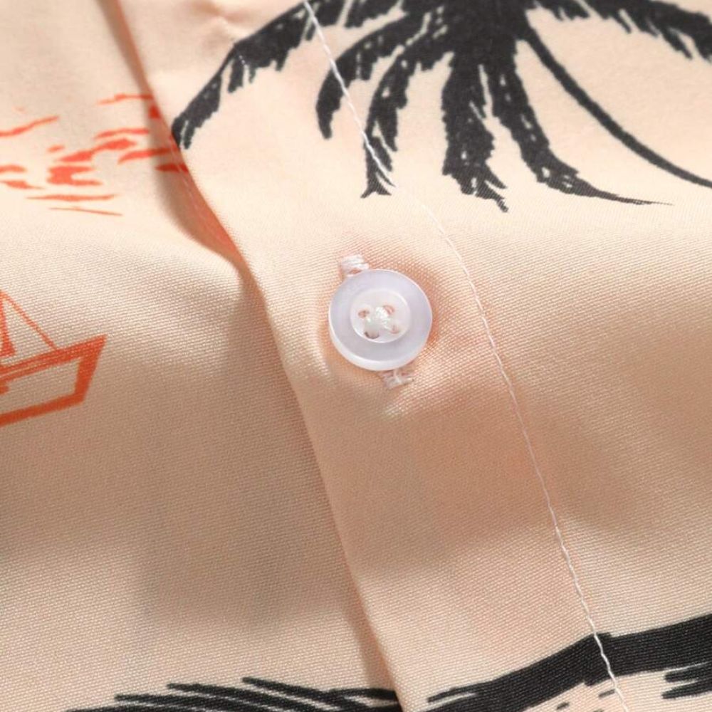 Detalhe do botão e acabamento da camisa masculina Vinser Jeribá bege com estampa litorânea.