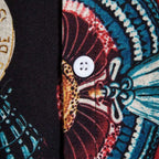 Detalhe do botão e da estampa oriental da camisa masculina Vinser Kyoto, com acabamento em tecido estampado nos tons azul, vermelho, preto e branco.
