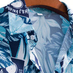 Detalhe da gola da Camisa Vinser Litoral Azul, destacando o acabamento do colarinho e a estampa tropical com folhas e flores em tons de azul, azul-marinho e branco.