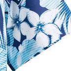 Detalhe da manga da Camisa Vinser Litoral Azul, destacando o acabamento da barra e a estampa tropical com folhas e flores em tons de azul, azul-marinho e branco.
