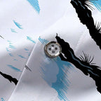 Close do botão e do tecido da Camisa Vinser Mar, destacando o acabamento premium, a costura reforçada e a estampa litorânea com coqueiros em preto e detalhes em azul sobre fundo branco.