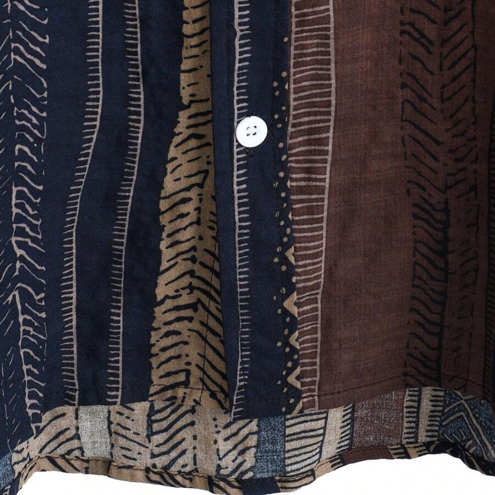 Detalhe do botão da Camisa Vinser Marrakesh, destacando as costuras reforçadas, o acabamento refinado e a estampa listrada étnica em tons de marrom, azul-marinho, bege e preto, evidenciando a qualidade do tecido e dos acabamentos.