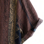 Detalhe da manga da Camisa Vinser Marrakesh, destacando o acabamento dobrado, as costuras reforçadas e a estampa listrada étnica em tons de marrom, azul-marinho, bege e preto, evidenciando a qualidade do tecido e dos acabamentos.