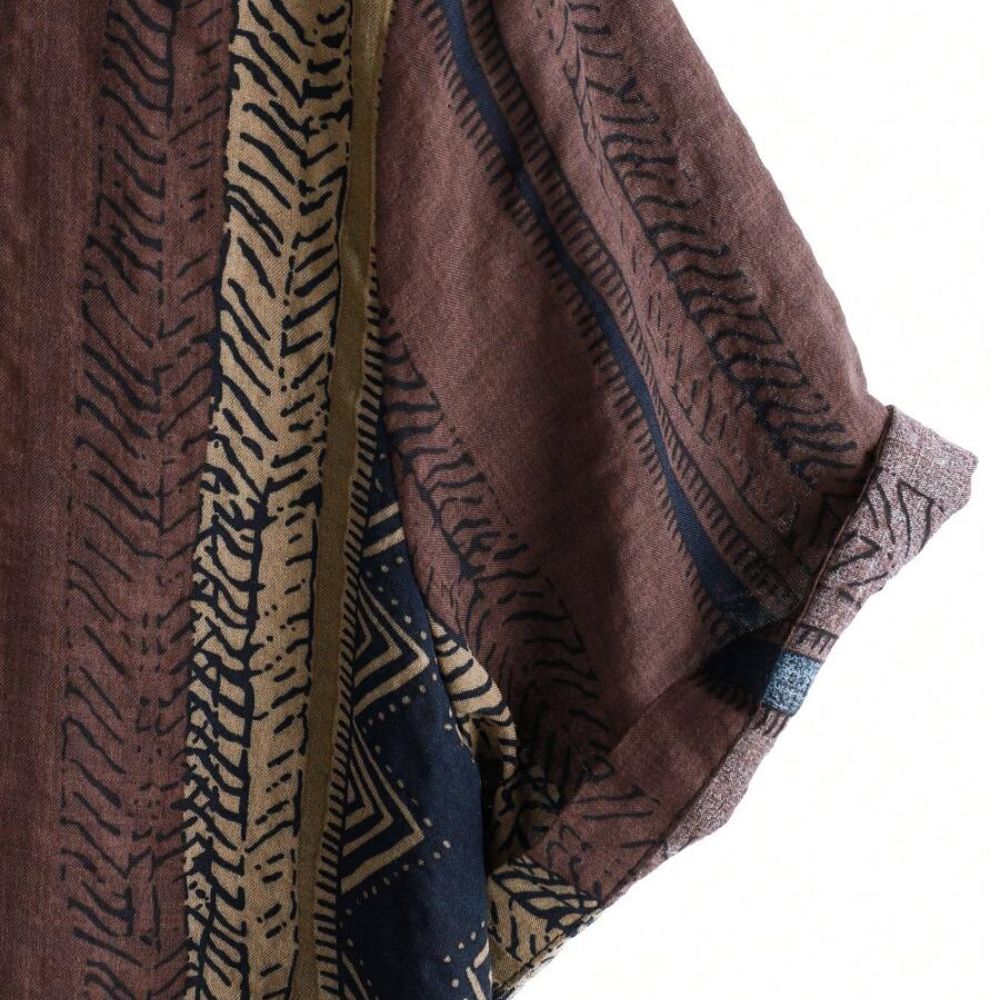Detalhe da manga da Camisa Vinser Marrakesh, destacando o acabamento dobrado, as costuras reforçadas e a estampa listrada étnica em tons de marrom, azul-marinho, bege e preto, evidenciando a qualidade do tecido e dos acabamentos.