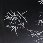Close da estampa da camisa masculina Vinser Midnight Sakura, com desenho inspirado em galhos de cerejeira em branco sobre fundo preto, destacando o tecido leve e o acabamento premium.