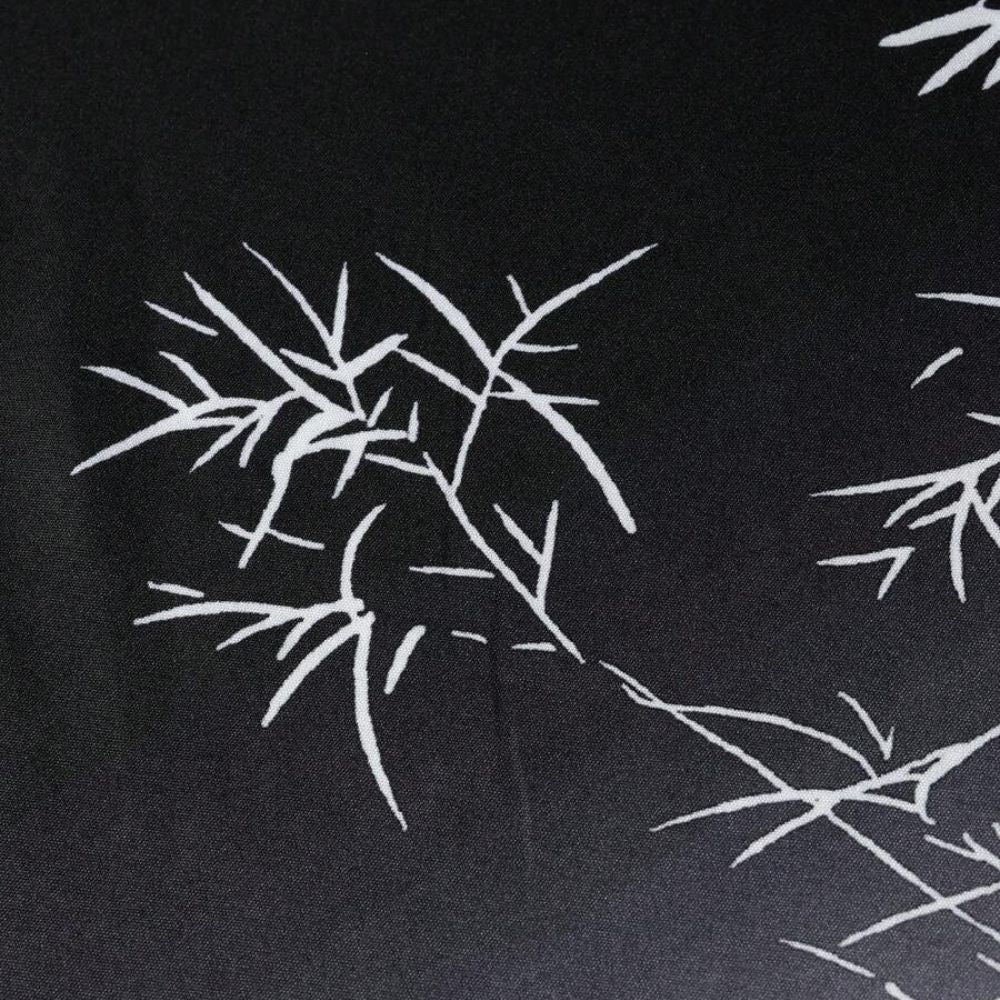 Close da estampa da camisa masculina Vinser Midnight Sakura, com desenho inspirado em galhos de cerejeira em branco sobre fundo preto, destacando o tecido leve e o acabamento premium.