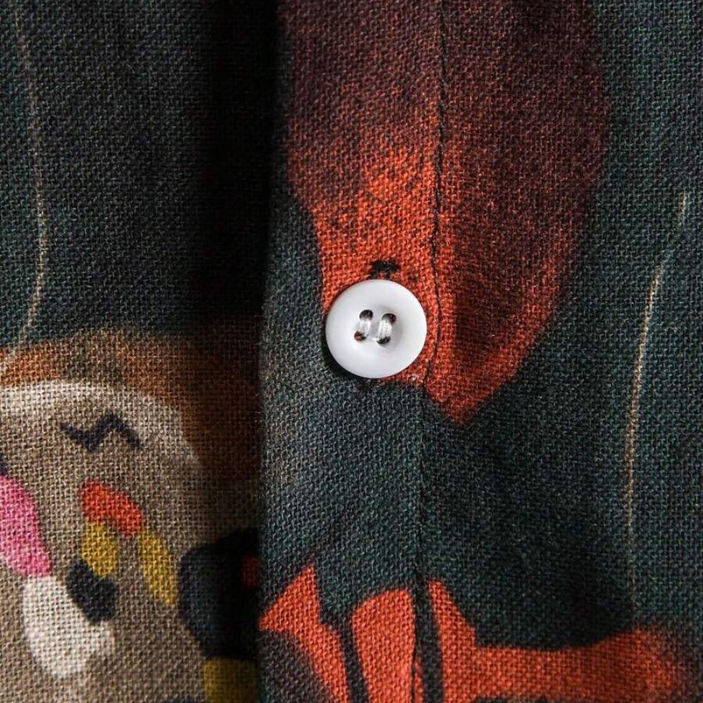 Detalhe da camisa masculina Vinser Niterói com botão branco e acabamento da estampa geométrica abstrata em tons escuros e terrosos.