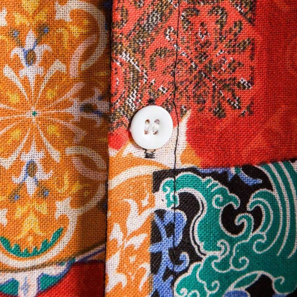 Detalhe da camisa masculina Vinser Olinda com estampa patchwork colorida e botão frontal.