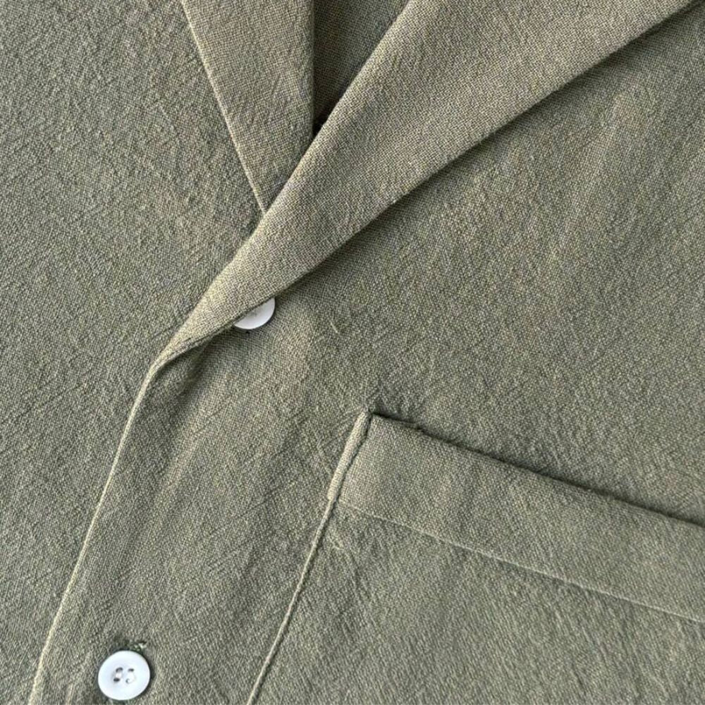 Detalhe do tecido da Camisa Vinser Oliva, destacando a textura suave, o acabamento refinado e o tecido leve na cor verde oliva, ideal para conforto e elegância no dia a dia.