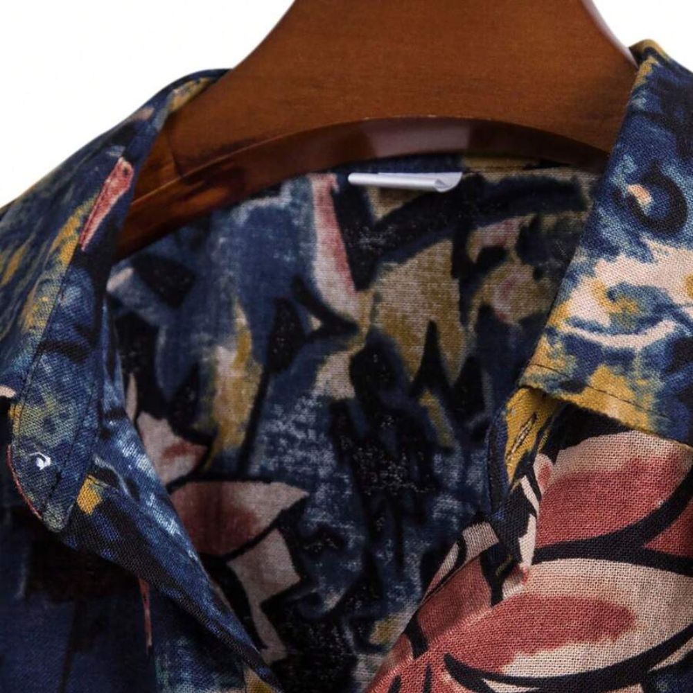 Detalhe da gola da camisa masculina Vinser Paraty com estampa abstrata em azul-marinho, mostarda e tons rosados.