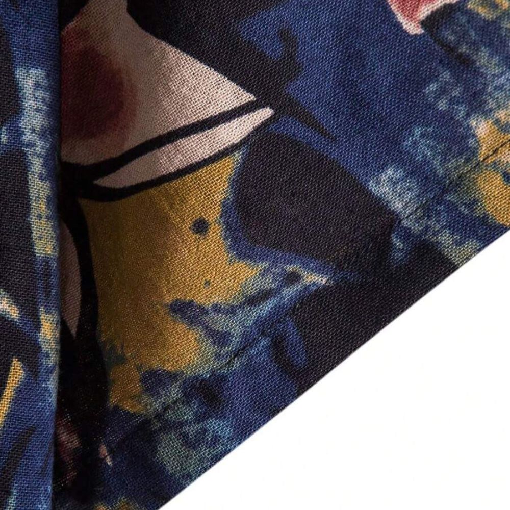 Detalhe do tecido da camisa masculina Vinser Paraty azul-marinho com estampa abstrata em tons de azul, mostarda e rosa, destacando a textura e o acabamento do tecido.