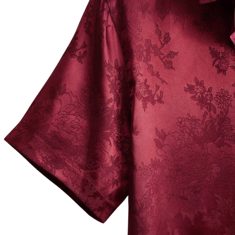 Detalhe da manga curta da camisa masculina Vinser Petrópolis em tom vinho, com estampa floral discreta e acabamento sofisticado.
