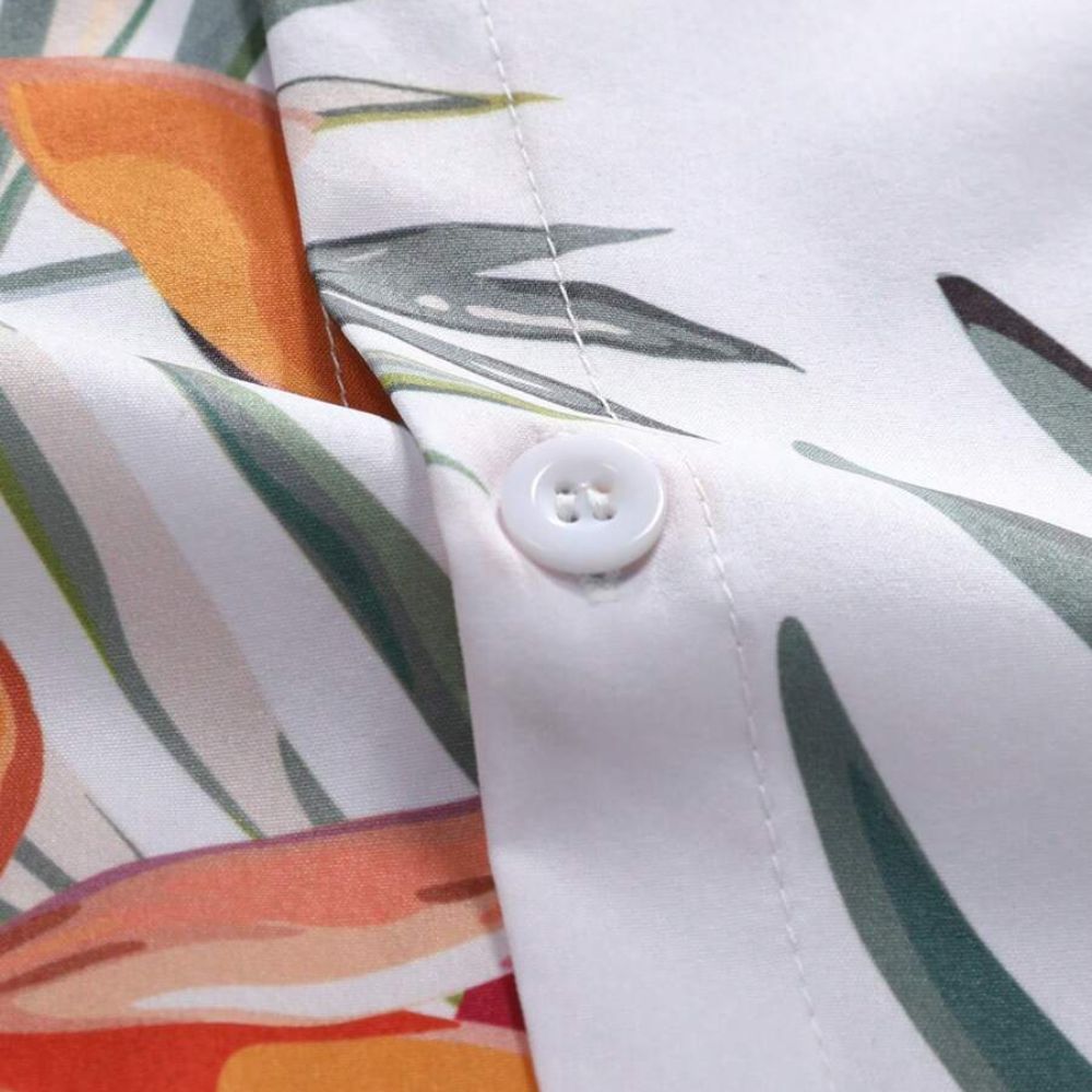 Close do tecido da Camisa Vinser Porto do Sol, destacando a textura suave, o botão frontal, o acabamento premium e a estampa tropical em tons de laranja, verde e branco.