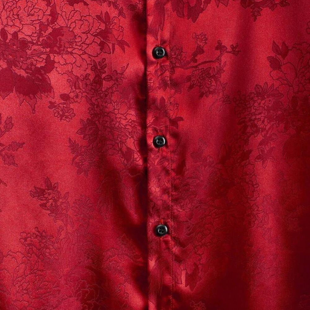 Detalhe do tecido da camisa masculina Vinser Riviera vermelha com textura floral acetinada em relevo e botões pretos. Tecido leve, macio, respirável e com acabamento premium para um visual sofisticado.