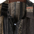 Detalhe da gola da Camisa Vinser Safari, destacando o colarinho estruturado, os botões frontais, o acabamento refinado e a estampa listrada em tons de preto, marrom e bege, evidenciando a qualidade premium da peça.