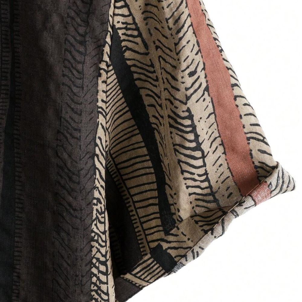 Detalhe da manga da Camisa Vinser Safari, destacando o acabamento dobrado, as costuras reforçadas e a estampa listrada em tons de preto, marrom e bege, evidenciando a leveza do tecido e a qualidade dos acabamentos.