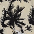 Detalhe da estampa tropical preta de folhas e palmeiras da Camisa Vinser Saint-Tropez em fundo bege
