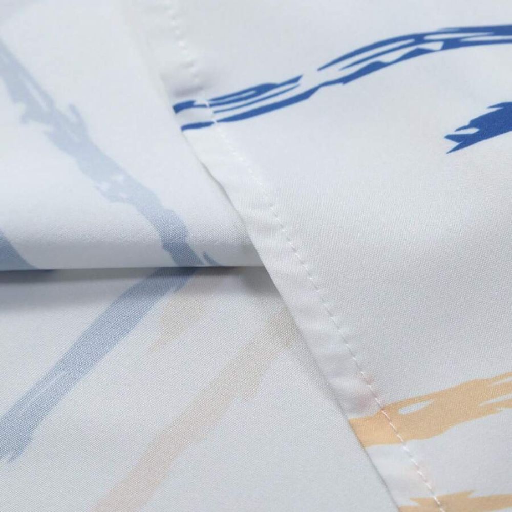 Detalhe da costura da Camisa Vinser Santorini, destacando o acabamento refinado, a precisão das costuras, a estampa listrada em azul e bege sobre fundo branco e a qualidade premium do tecido, garantindo durabilidade, conforto e elegância.