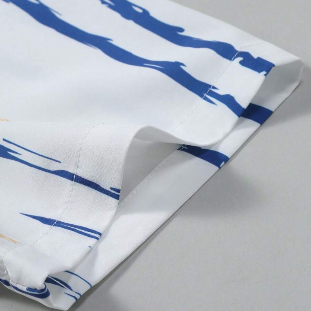 Detalhe da manga da Camisa Vinser Santorini, destacando o acabamento dobrado, as costuras reforçadas e a estampa listrada em azul e bege sobre fundo branco, evidenciando a leveza do tecido e a qualidade dos acabamentos.