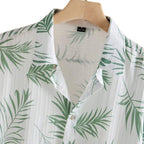 Detalhe da Camisa Vinser Seychelles branca com gola aberta, botões e estampa de folhas verdes